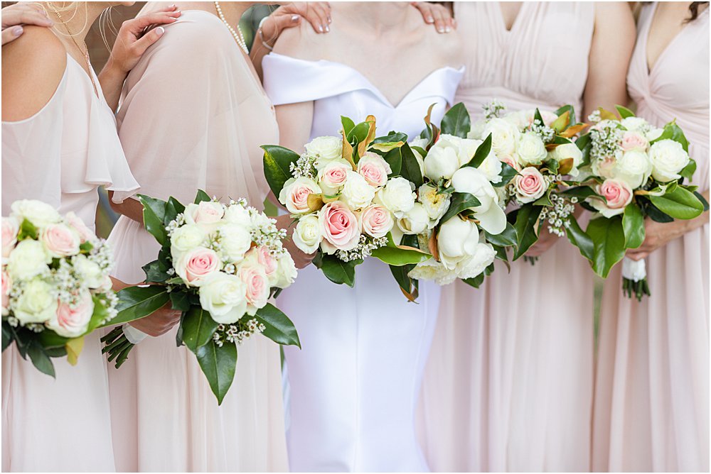 Elegant blush, white, and green wedding bouquets; bridesmaids in blush pink