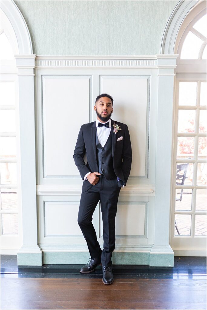 Groom poses for photo at The Estate at River Run during whimsical styled wedding editorial