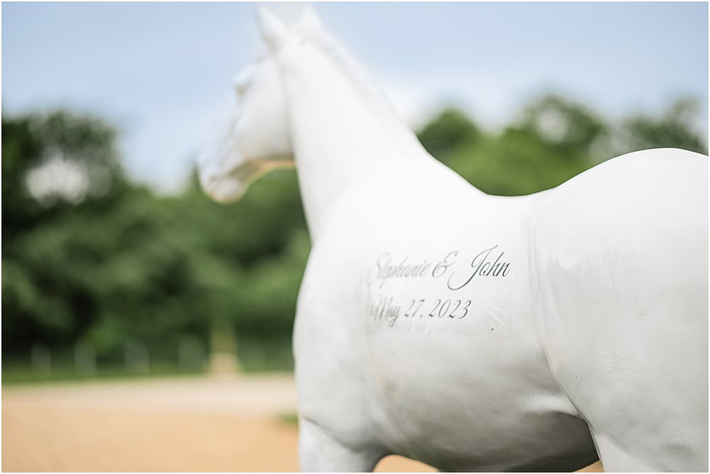 John and Stephanie's names and wedding date are written in script on a painted white horse statue in front of Upper Shirley