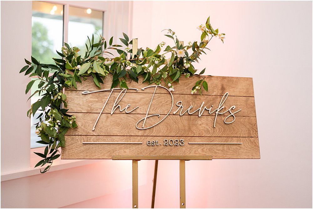 A modern romantic sign - wood with script reading "The Dreviks est. 2023" welcomed guests to the modern romantic wedding reception.