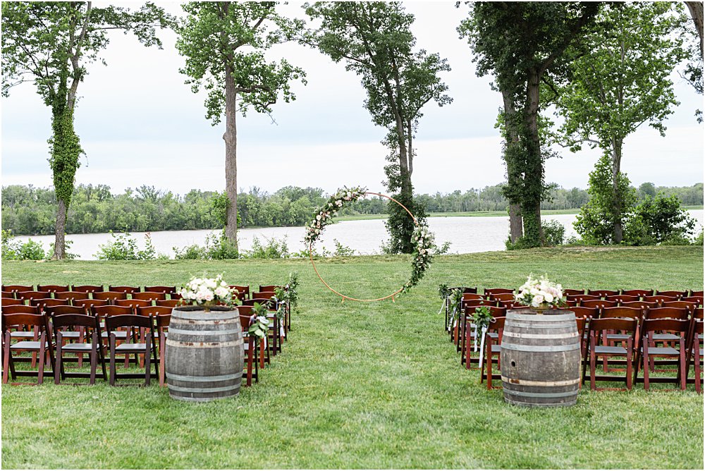 The modern romantic wedding ceremony took place on the lawn at Upper Shirley, overlooking the James River. A large hoop adorned with florals served as the alter.