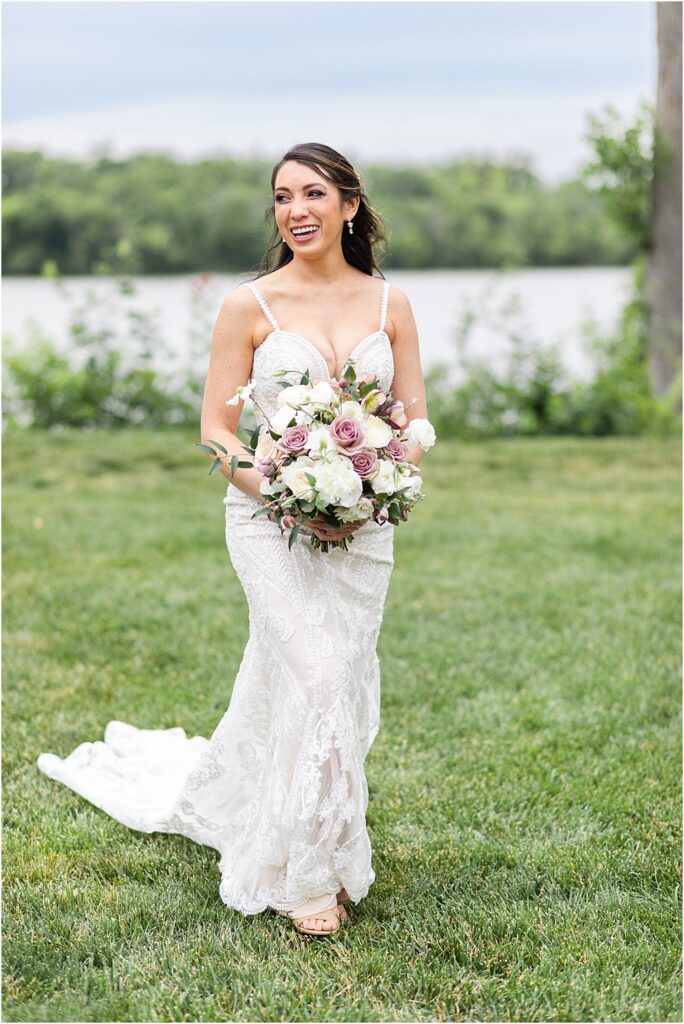 The bride poses for a photo with her bouquet on the lawn overlooking the James River at Upper Shirley in Charles City, VA