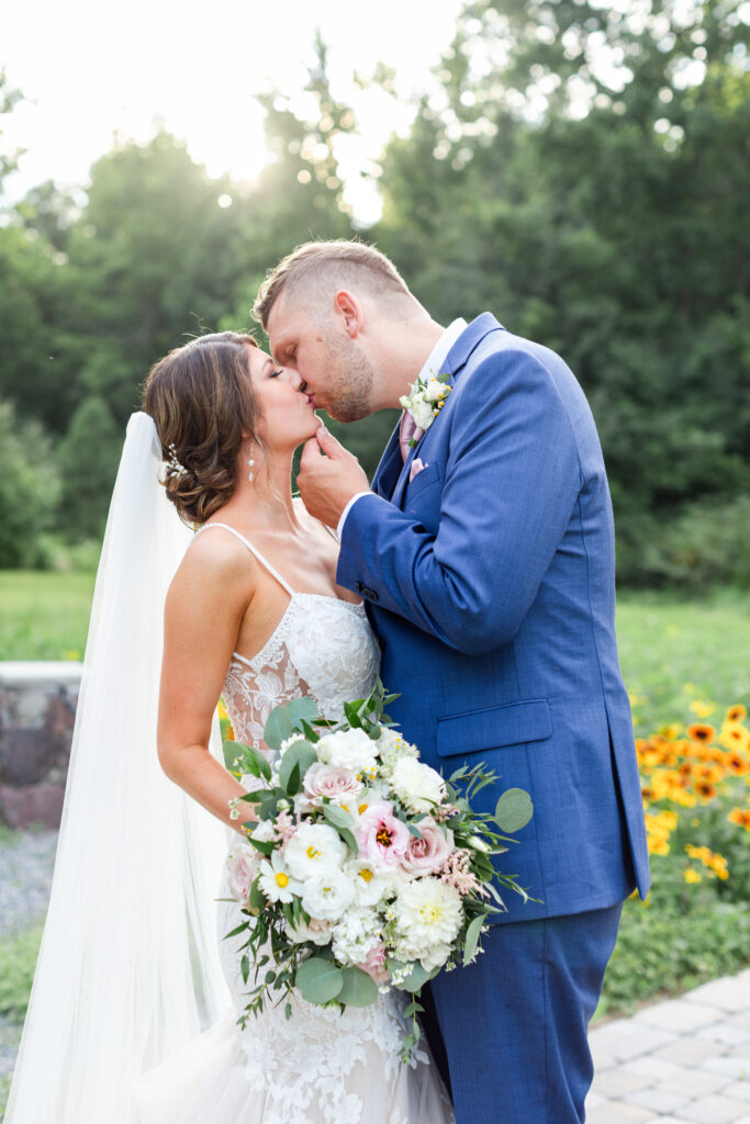 bride and groom kiss during romantic barn wedding day