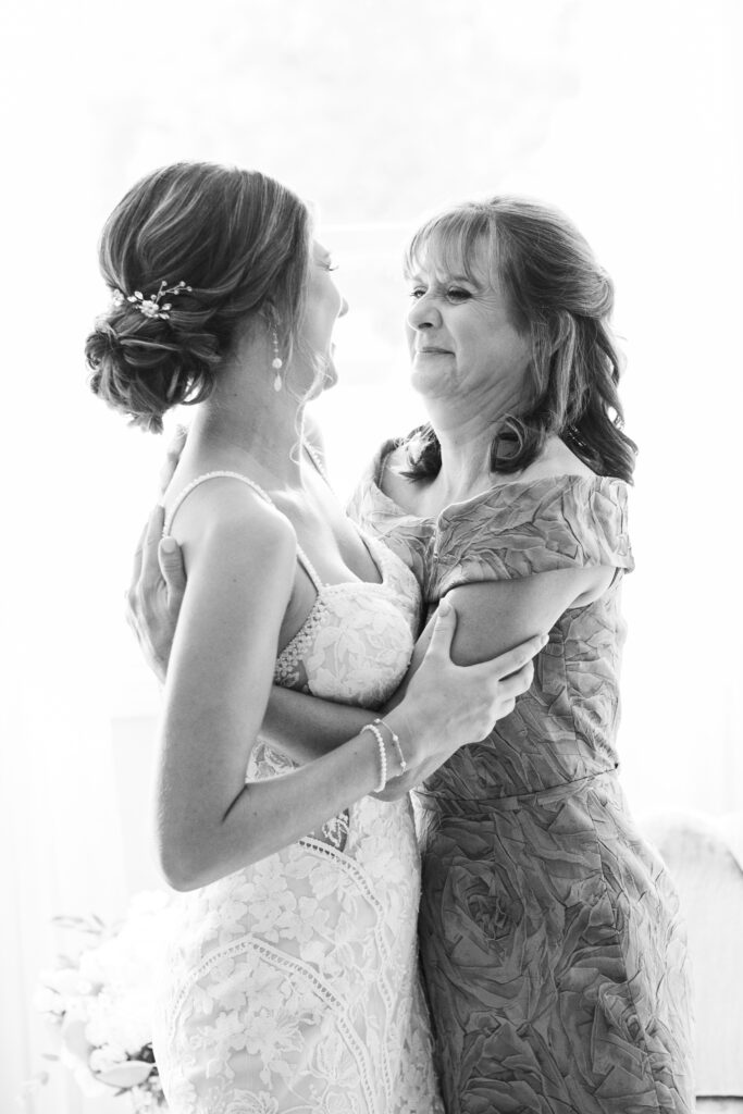 mom hugs bride during romantic barn wedding in King William, VA