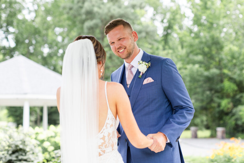 groom smiles at bride during first look on romantic barn wedding day in King William, VA