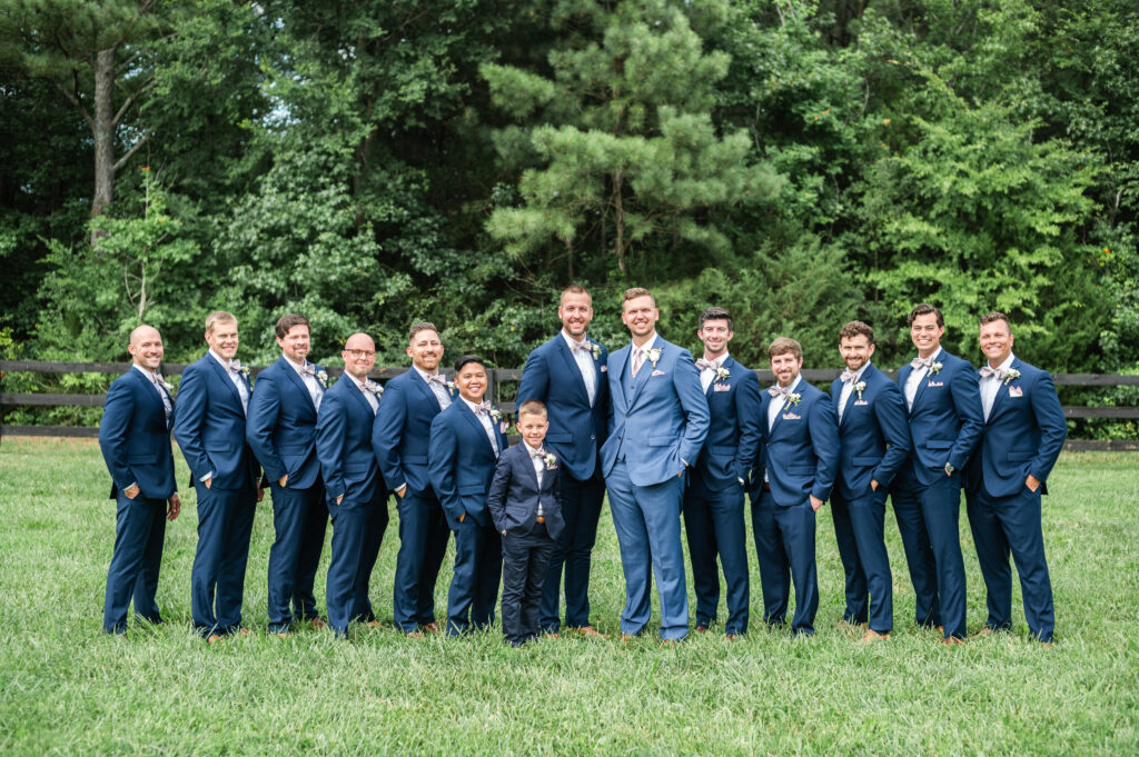 The groomsmen pose for a photo with the groom during romantic barn wedding in King William, VA