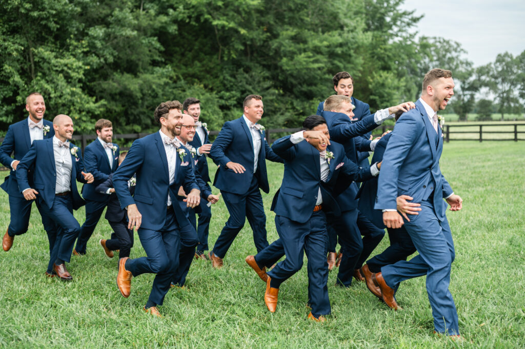 The guys run and laugh together during romantic barn wedding in King William, VA