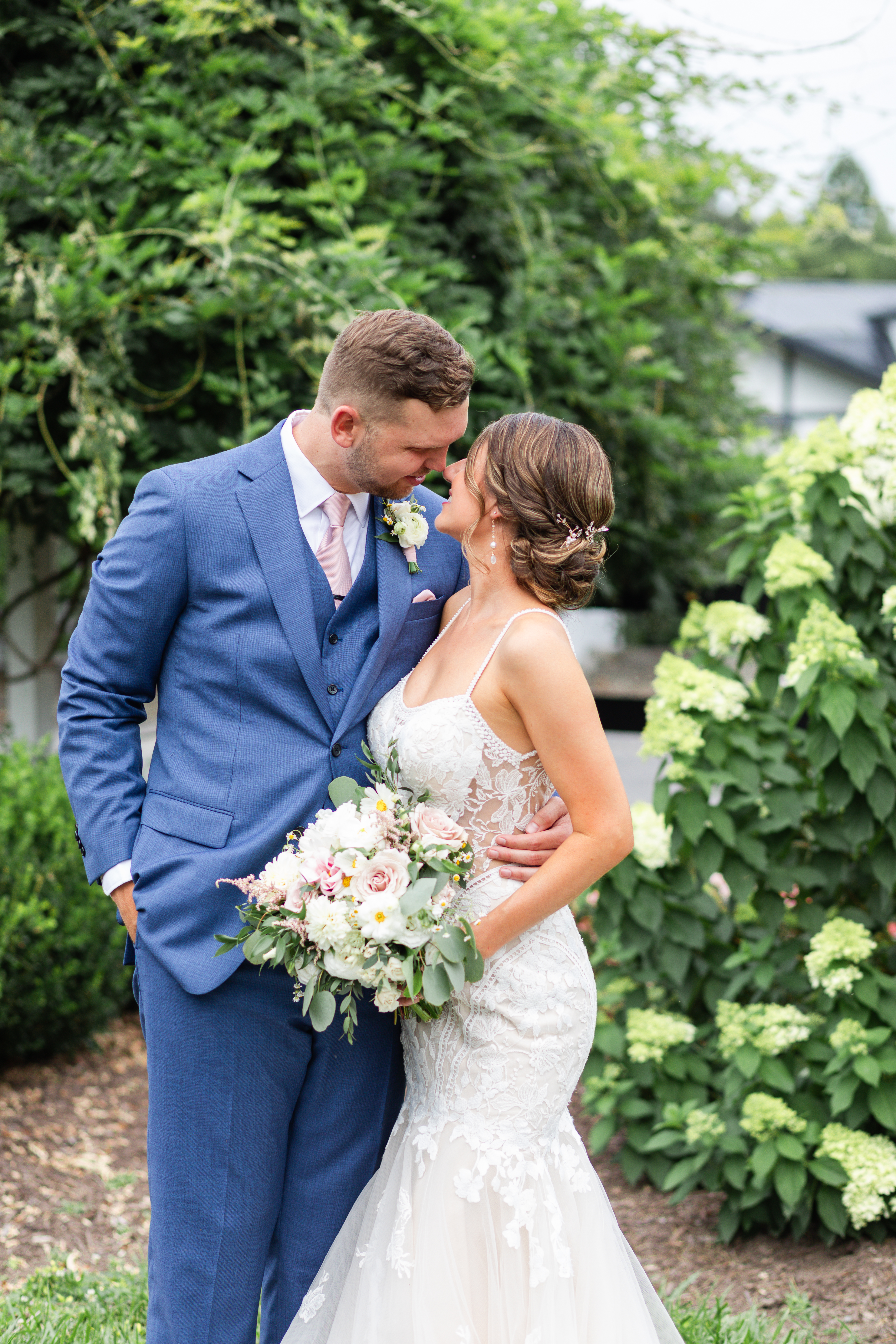 newlyweds embrace in the gardens at Altria Farm during their romantic barn wedding