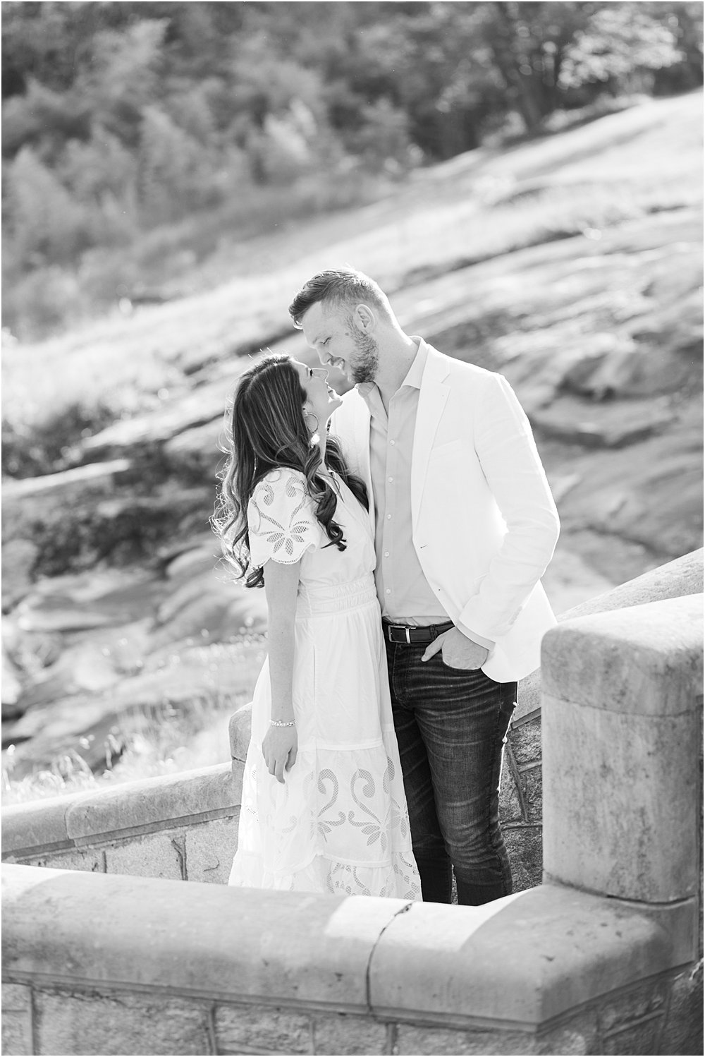 The couple, smiling and nose to nose, prepare to kiss beneath at the top of a stone staircase at Maymont during their effortlessly chic engagement session.