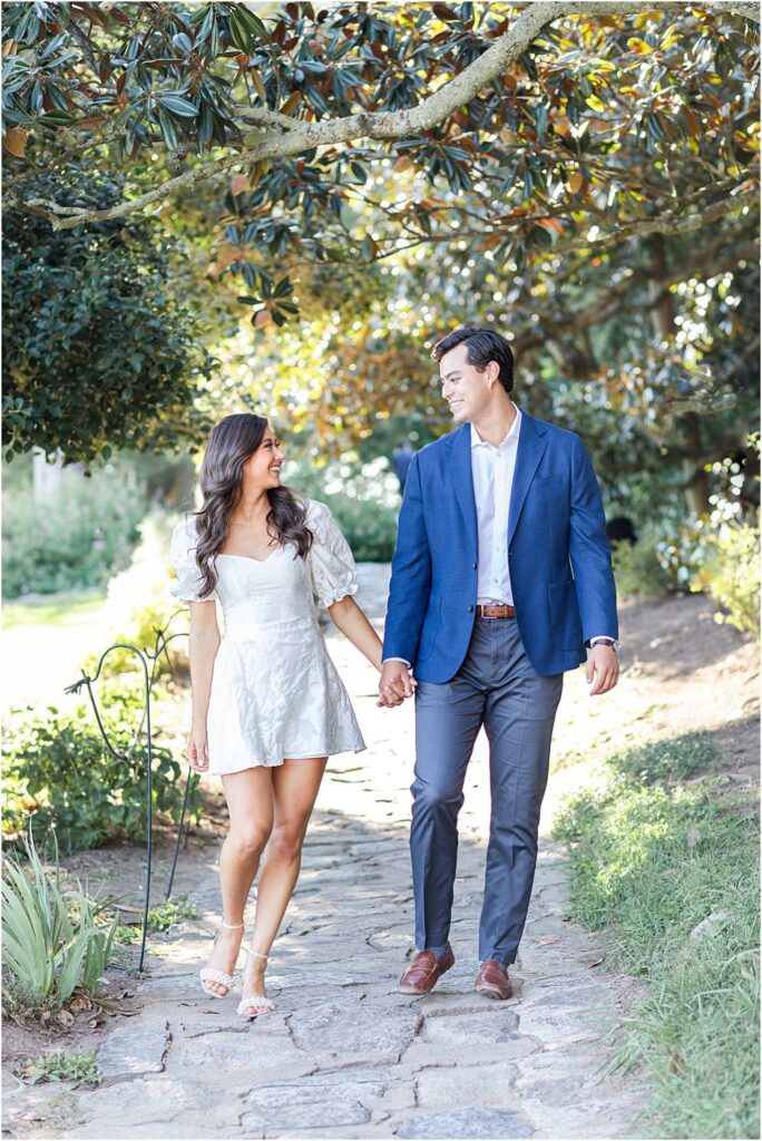 The couple strolls hand in hand along stone path during classic engagement session at Maymont Park in RVA.