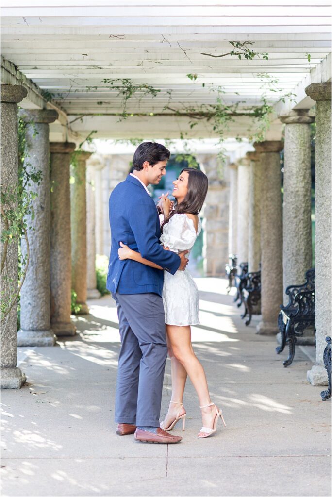 Gabriella and Raphael dance beneath the Italian columns at Maymont during classic engagement session in Richmond, Virginia.