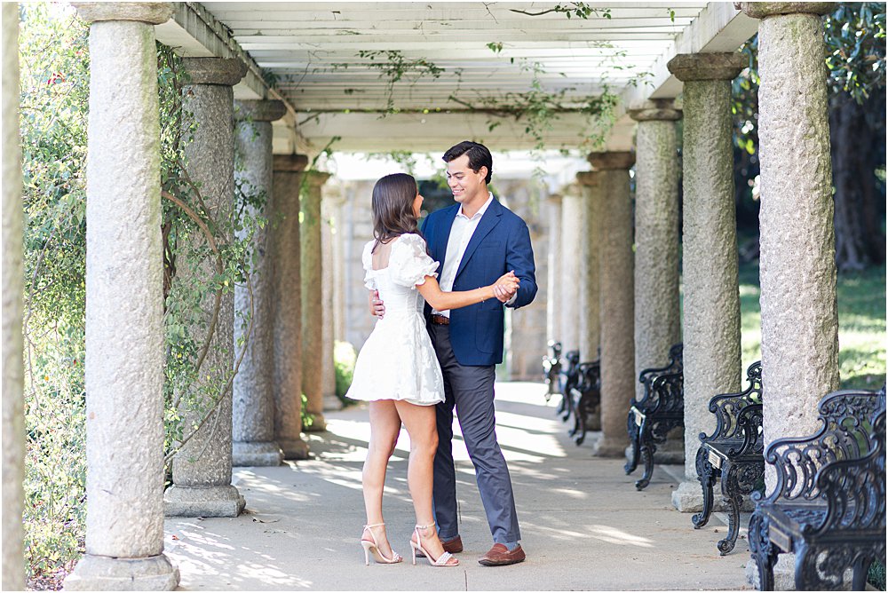 Gabriella and Raphael dance beneath the Italian columns at Maymont during classic engagement session in Richmond, Virginia.
