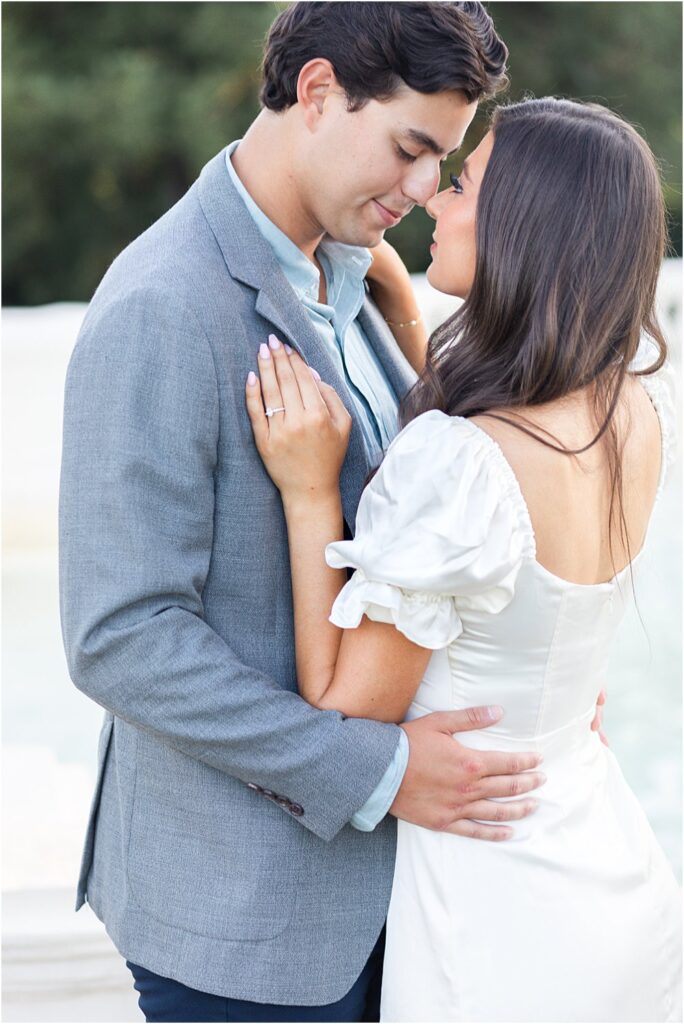Raphael, eyes closed, pulls Gabriella close. The couple is nose to nose. She stares up lovingly during classic engagement session at Maymont Park in Richmond, VA.