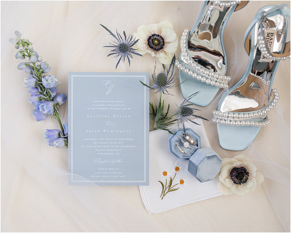 classic romantic wedding invite with blue wedding shoes and wedding rings in blue box.