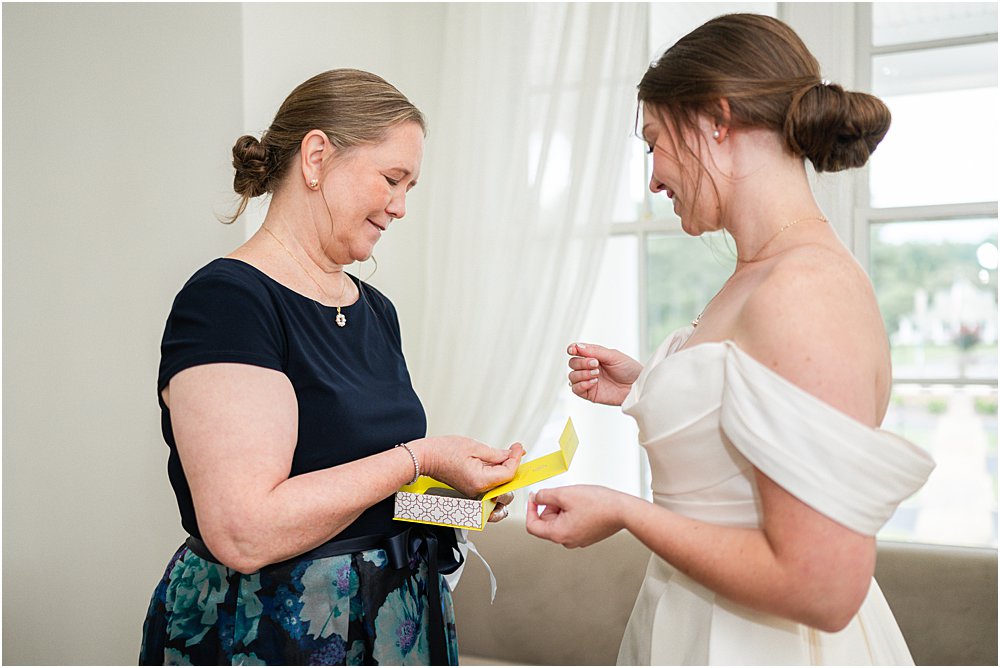 mother of the bride giving gift to bride as she gets ready at the Estate at Independence
