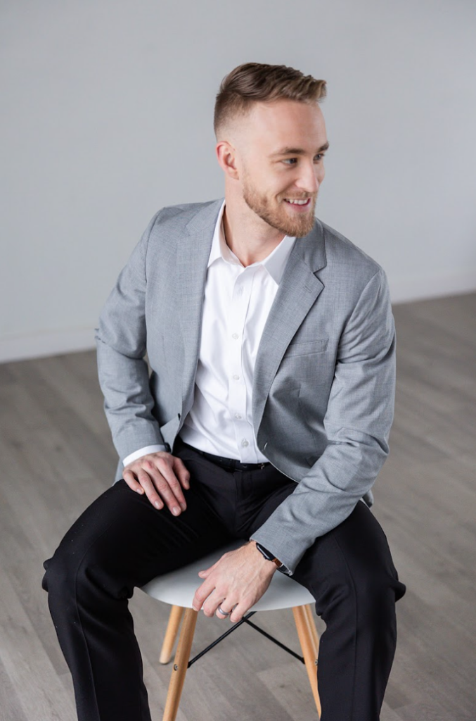 Man sitting in a chair in a photo studios posing for a headshot