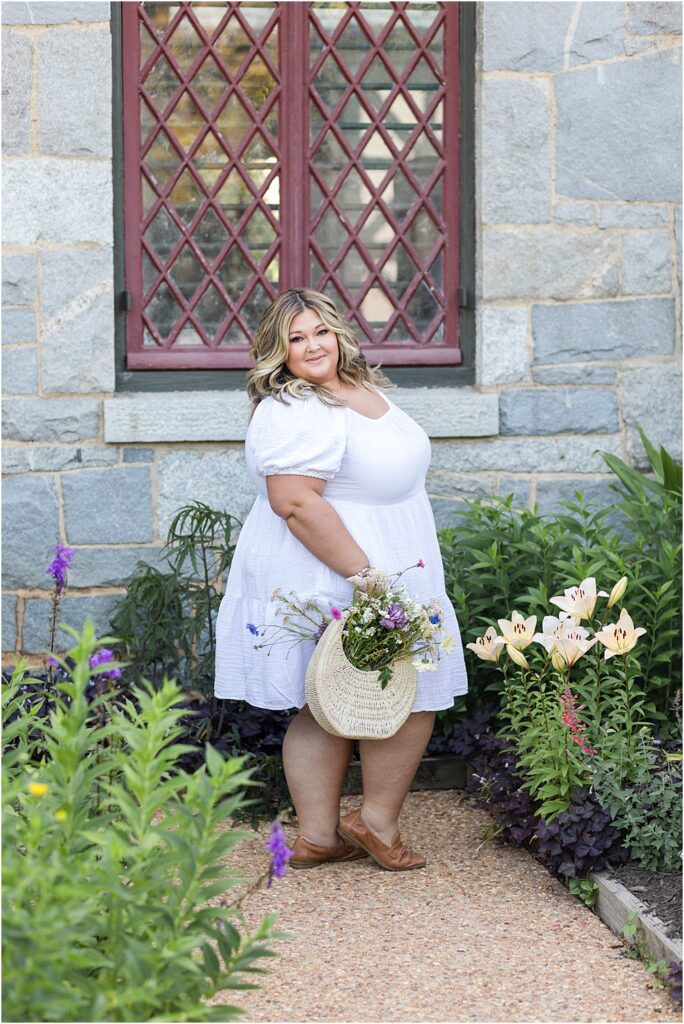 Kelsea Dayberry from Radiant Reflection posing with flowers from Field Floral in a branding photography session.