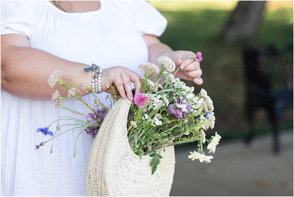 Kelsea Dayberry holding a basket of flowers from Field Floral during a branding photography session.