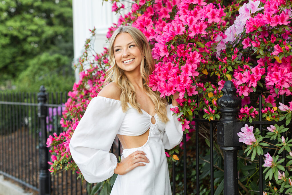 Dallas posing with pink flowers for her senior portraits.