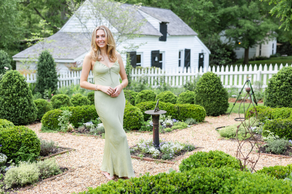 Nora wearing a green dress in the garden at Historic Tuckahoe for her Senior Portrait Session 