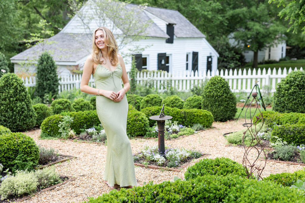 Nora standing in the garden during senior portraits at historic tuckahoe