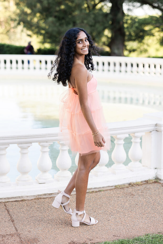 Veda posing next to water fountain for senior portraits at maymont