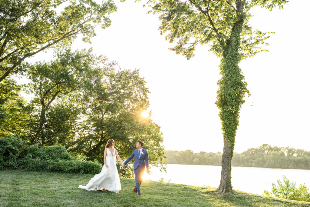 Bride and Groom walking at Sunset by the water at Upper Shirley Vineyards